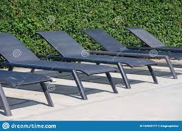 Une Rangee Des Chaises Vides De Piscine Pour Se Coucher Avec Un Fond Vert Un Jour Ensoleille Image Stock Image Du Fond Coucher 154923177