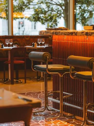 À Porte Maillot, avec Maison Mayane, l'Atelier Entrecôte & Volaille garde son âme de bistrot français mais se permet un léger twist. Tons beiges, rouges et bois créent une atmosphère plus contemporaine