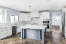 White Cabinets And Blue Gray Island Combine For A Casual Elegance In This Custom Built Home By King S Court Bu Custom Homes Kitchen Remodel Custom Home Designs
