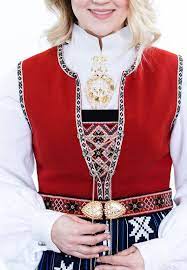 Sølvet består av ei dobbel halssølje, gjerne med grønn stein, mansjettknapper, 3 sett maljer, kjede med spyd, veskekrok og beltespenne. Sunnhordland Damebunad Raud Vest Stord Solhjell