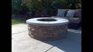 You will need the required fire pit tools such as 55 york blocks, 25 wall caps, two tubes of masonry adhesive, ten 50 pound bags of crushed rock, 6 50 pound bags of decorative rocks, and one metal fire ring. How To Build A Fire Pit With Stone Veneer Facing Diy Add A Bbq Grill Youtube