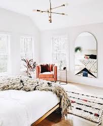 Bright White Master Bedroom With Gorgeous Wall Mirror And Leather Chair Brass Light Fixture Home Bedroom Bedroom Decor Bedroom Design