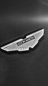 Despite the development of an iconic product range, the 1970s saw a change in ownership for aston martin as 'company developments ltd' took over the firm in 1972. Simple Aston Martin Logo Dark Background Iphone 6 Wallpaper Download Iphone Wallpapers Ipad Wall Aston Martin Harley Davidson Wallpaper Car Iphone Wallpaper