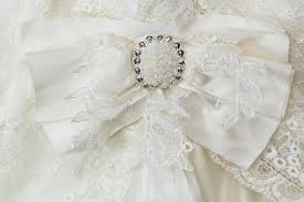 Finden sie hochzeit broschen für den besonderen tag. Roter Bogen Mit Brosche Auf Hochzeitskleid In Den Handen Der Braut Stockbild Bild Von Bogen Perle 98648681