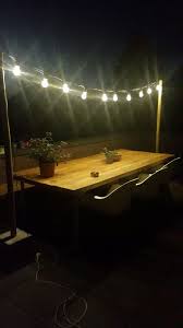 Terras Met Romantische Verlichting En Zelfgemaakte Tafel Van Eiken Houten Balken En Steigerbuizen Terras Verlichting Tuinverlichting Houten Terras