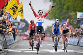 Mathieu van der poel liegt auf dem boden, sein rennrad zu seinen füßen, um ihn herum drängen gratulanten auf den radprofi ein. Van Der Poel Favoriet Voor Amstel Gold Race Na Zege In Brabantse Pijl Het Parool