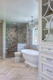 Modern primary bathroom boasting a white freestanding tub surrounded by brown tiles walls and a a classy primary bathroom with a beautiful chandelier. No Matter The Number Of Bathrooms In Your House The Master Suite Deserves The Grandest Bathroom Remodel Master Farmhouse Master Bathroom Small Master Bathroom