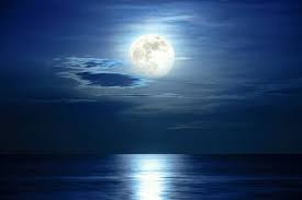 Super lua cheia e nuvem no céu azul acima do horizonte do oceano à meia- noite,