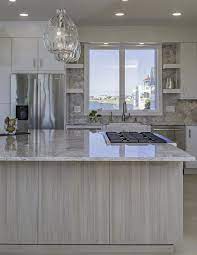 Reclaimed oak wood tops are a unique spin on the classic butcher block countertops that have been trending across the nation. Contemporary White Laminate Kitchen With Gray Island Crystal Cabinets