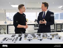 Prime Minster David Cameron meets gearbox technician Mark Luckett during  his visit to the Lotus Renault GP's Whiteways Technical Centre in  Oxfordshire Stock Photo