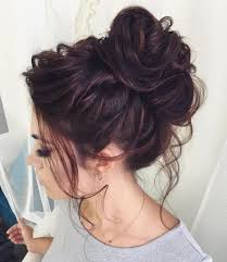 A bun is a type of hairstyle in which the hair is pulled back from the face, twisted or plaited, and wrapped in a circular coil around itself, typically on top or back of the head or just above the neck. Curly Messy Bun Long Hair Bun Hairstyles For Long Hair Hair Styles Long Hair Updo