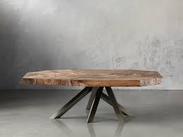 Modern trestle table bases and matching table edges are shaped using solid alder wood and alder veneers, which are painted and lacquered to bring out the lumber's natural features and accentuate the tabletops' dark and varied tones. Carrinna Coffee Table Arhaus