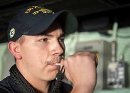 Boatswain's Mate 3rd Class Garrett Hinten sounds the