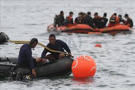 Rescuers investigate suspected debris from the plane. Lgs0ib2pdbtp1m