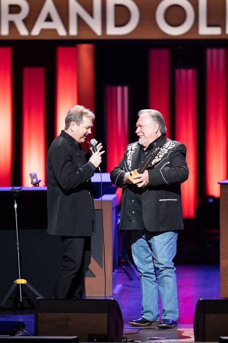 Gene Watson receiving recognition on the Grand Ole Opry stage., do AI tạo