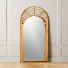 The mirror is fashioned in the arched style of a cathedral windowpane. Arched Natural Rattan Floor Mirror