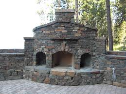 Two story house with large stone fireplace chimney in fall. Natural Stone Fireplaces Mutual Materials