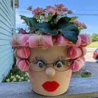 Terra cotta pot decorated with curlers and eyelashes
