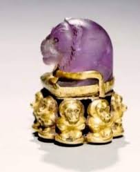 Pendant representing a lion's head, fixed on a base surrounded by eight  seated baboons. The Lion's Head, a New Kingdom heirloom, was probably a game  piece that was adapted in the Napatan