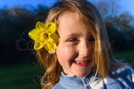 Cute, small girl holding a small bouquet of beautiful, yello
