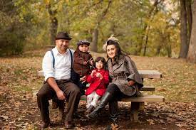 Fall Leaves As A Backdrop For A Family On A Park Bench Outdoor Family Pictures Family Photoshoot Family Photography