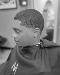 This haircut combines the sleek, modern look of a low bald taper with the  stylish, textured appearance of 360 waves, making it a popular choice for  those seeking a fresh and refined