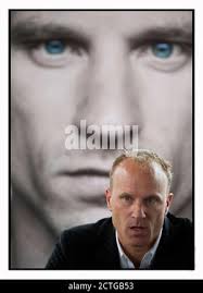 DENNIS BERGKAMP AD AMSTERDAM AL LANCIO DELLA SUA BIOGRAFIA, DI FRONTE AD  UNA FOTO DELLA COPERTINA DEL SUO LIBRO. IMMAGINE: © MARK PAIN