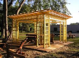 Points of interest ● medium stained wooden pergola wrapped around tree ● mortared stacked stone wall with wood planks supporting attached pergola ● 6 tree stump stools ●. Wood Pergolas Landscaping Network