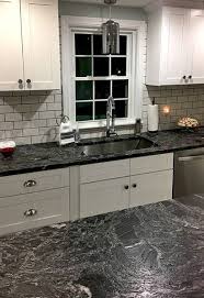 The large stainless steel refrigerator adds modernity to the look and is matched by the pair of simple pendant lamps over the kitchen island's ornate casework and wood carved plinths. Tuscany White Cabinet Display 2 500 Builders Surplus Tuscan Kitchen Replacing Kitchen Countertops Dark Countertops