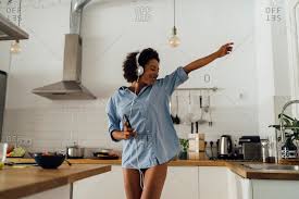 Today, you can find the music you love for free online, and it's all completely legal. Woman Dancing And Listening Music In The Morning In Her Kitchen Stock Photo Offset