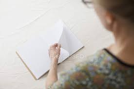 Plain blank white notebook isolated on a white. Over Shoulder View Or Woman Turning Page Of Blank Book At Table Knowledge Anticipation Stock Photo 178064322