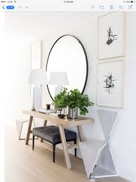 Minimalist Entryway With Oversized Round Mirror Over Light Toned Table From Architectural House Beautiful Magazine Interiors Hallway Designs Entry Table Decor