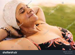 水着を着て怠け者の上でくつろぐ至福の老女。贅沢なスパリゾートで夏休みを楽しむケアフリーの高齢女性。退職後に楽しく過ごす幸せな熟女。写真素材2129912873  | Shutterstock