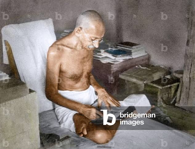 Image of Mahatma Gandhi reading in his hut, Wardha, 1940 (photo)