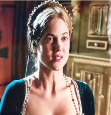 In the archery scene from *Wolf Hall*, Henry VIII is playing archery in the  garden with his courtiers, enjoying a moment of leisure and camaraderie.  The atmosphere is light-hearted, with Henry demonstrating