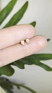 Pequeños aretes tipo calavera con diamantes y oro de 14 quilates