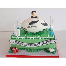 Fresh cholocate delicious cake with maracoons around it and with soccer ball on sticks on the table against white background. Pictures On Football Field Birthday Cake