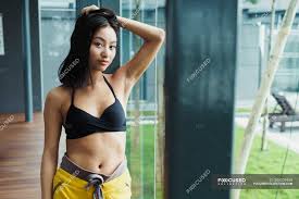 There's not enough hair spray in the world. Pretty Asian Woman In Sportswear Touching Hair And Looking At Camera Athlete Holding Stock Photo 204209468