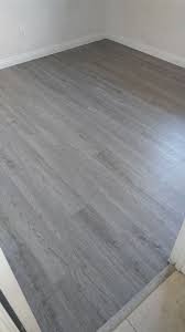 But then it clicks in to the plank beside it. Before And After Photos Of A Plank Vinyl Installation In Midland Gray Color Flooring Plankvinyl House Flooring Grey Wood Floors Living Room Grey Wood Floors