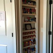 A marble trimmed spice rack, finished with art hanging from white backsplash tiles, is built into the sidewall of a large cooking alcove. Built In Adjustable Shelf Spice Rack Ryobi Nation Projects