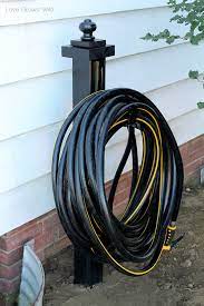 Position the wall mount hose storage holder onto the post and attach it using wood screws. Diy Garden Hose Holder Love Grows Wild