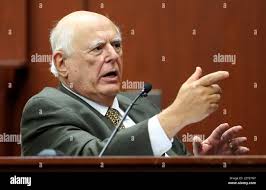 Dr. Vincent DiMaio, a forensic pathologist and gunshot wound expert, makes  a gun gesture while testifying for the defense in George Zimmerman's trial  in Sanford, Florida, Tuesday, July 9, 2013. Zimmerman is