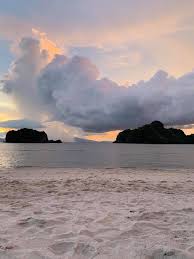 Gambar diatas adalah salah satu contoh gambar pemandangan pantai, karena menggambarkan dengan jelas pemandangan pantai dengan menyertakan objek papan surf, pohon kelapa, laut, dan sebagainya di dalam gambar. Pemandangan Pantai Pakej Percutian Aulia Homestay Facebook