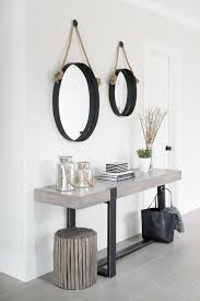 Two Captain S Hanging Mirrors Stand Over A Concrete Console Table Alongside A Gray Wash Floor Entrance Table Decor Console Table Hallway Console Table Styling