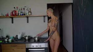 Bald beauty cooks naked and fingers her twat