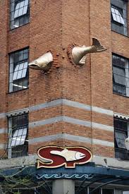 transcendence a fish flying through a building a sculpture by keith jellum sculpture street art sculptures