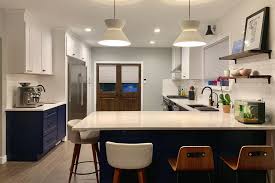 The navy and white color scheme is accented with the wood on the sleek modern bar stools and the lovely wooden floor. Are Navy Blue Kitchen Cabinets In Style Yes If Paired With White