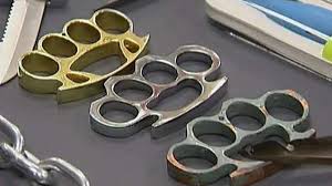 Blow With Brass Knuckles. The Hand Of An Elderly Woman Clutches A Metal Brass  Knuckles Stock Image - Image Of Brass, Gesture: 246856503