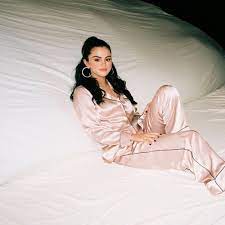 The dancer is a woman with long brown hair covered by an orange beanie. Selena Gomez I Can T Get Enough S Stream