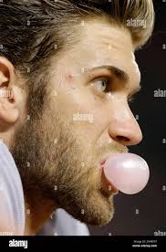 Washington Nationals' Bryce Harper blows a bubble as he watches from the  dugout in the ninth inning of an interleague baseball game against the  Baltimore Orioles, Thursday, July 10, 2014, in Baltimore. (